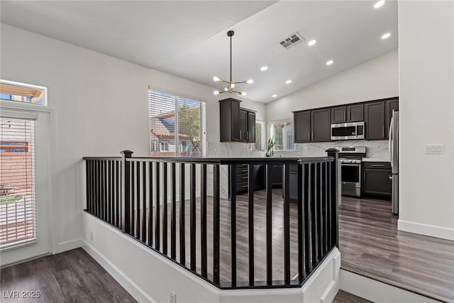 kitchen with dark wood finished floors, visible vents, backsplash, and stainless steel appliances