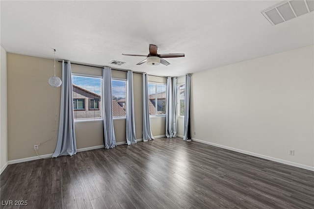 spare room with dark wood-style floors, ceiling fan, and visible vents