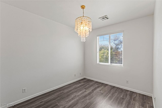 unfurnished room with a notable chandelier, dark wood-type flooring, baseboards, and visible vents