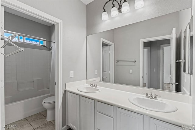 full bathroom with toilet, a sink, double vanity, and tub / shower combination