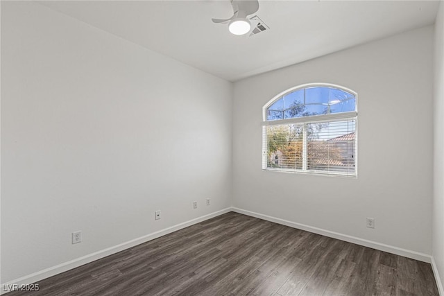 empty room featuring baseboards, dark wood-style flooring, ceiling fan, and visible vents
