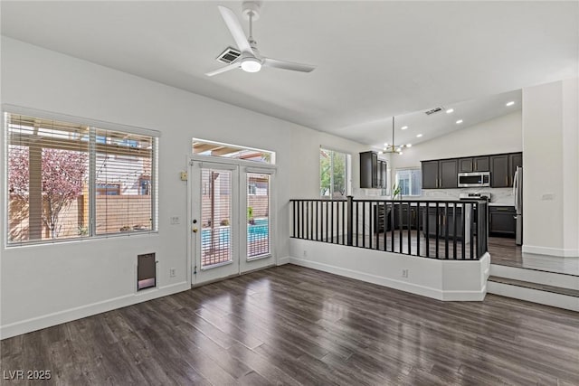 unfurnished living room with ceiling fan with notable chandelier, dark wood-style floors, lofted ceiling, baseboards, and recessed lighting