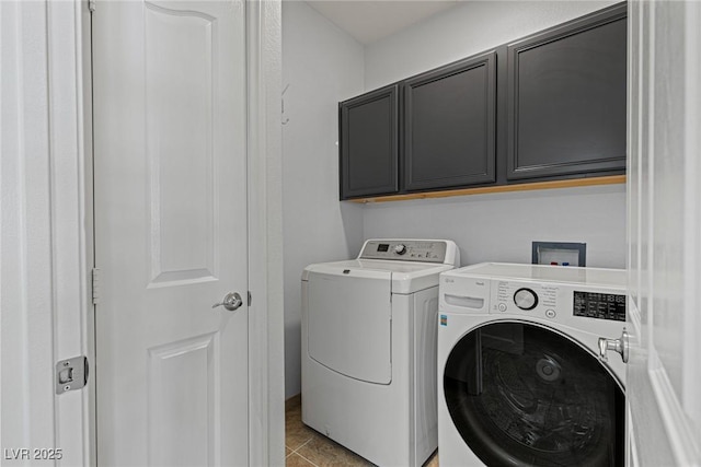 laundry room with light tile patterned floors, washer and clothes dryer, and cabinet space