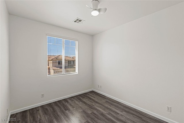 spare room with baseboards, dark wood-style floors, visible vents, and ceiling fan