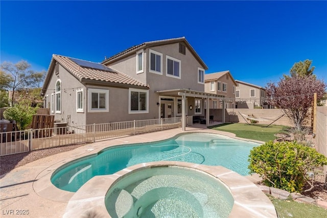 view of swimming pool with a fenced backyard, a pool with connected hot tub, a pergola, and a patio area