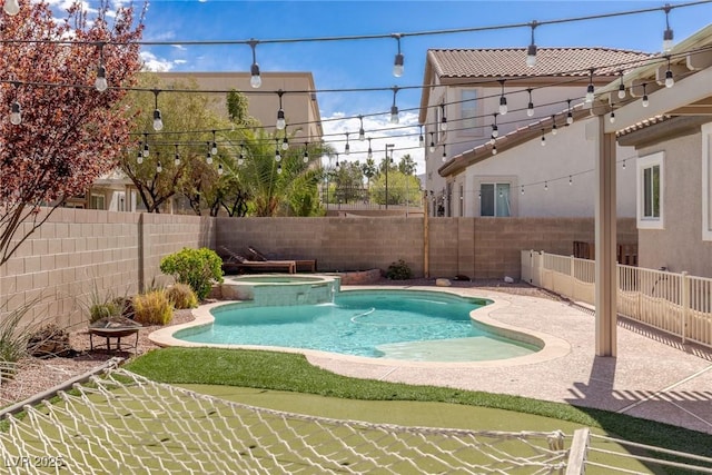 view of pool with a fenced backyard and a pool with connected hot tub