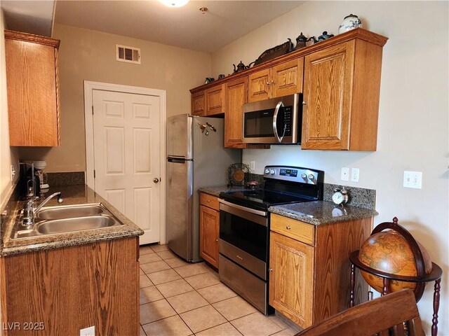 3550 Bay Sands Dr Unit 3077, Laughlin, NV 89029 - kitchen with light tile patterned floors, stainless steel appliances, a sink, visible vents, and brown cabinets