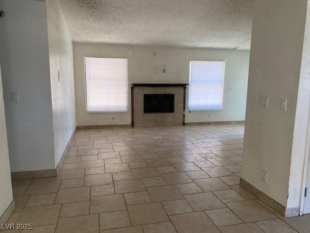 7732 Blackbird Ave, Las Vegas, NV 89145 - unfurnished living room with a textured ceiling and a tiled fireplace