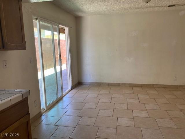 7732 Blackbird Ave, Las Vegas, NV 89145 - unfurnished dining area with a textured ceiling