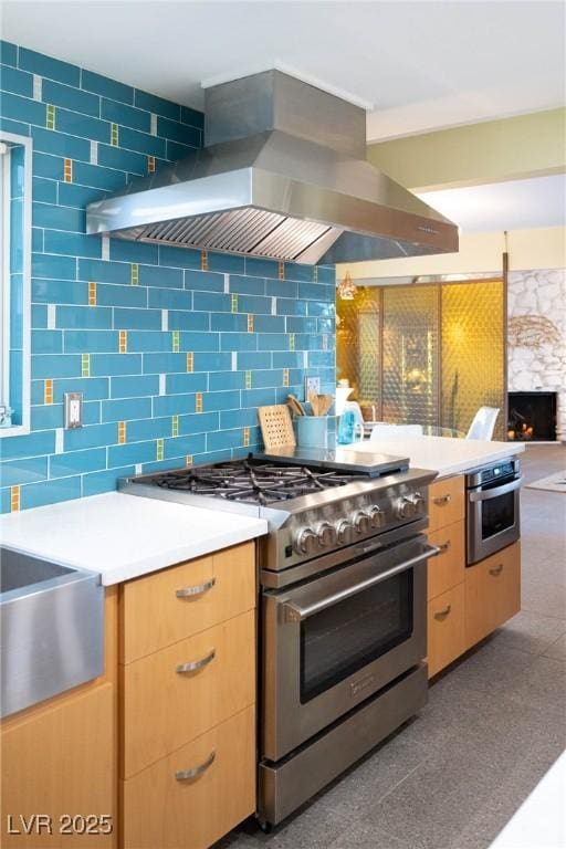 3586 Spencer St, Las Vegas, NV 89169 - kitchen featuring island range hood, stainless steel appliances, light countertops, light brown cabinets, and tasteful backsplash