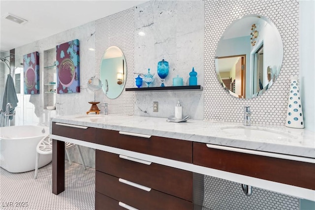 3586 Spencer St, Las Vegas, NV 89169 - bathroom featuring tile walls, a soaking tub, a sink, visible vents, and double vanity