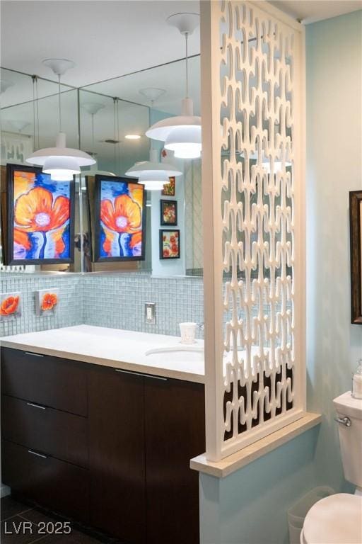 3586 Spencer St, Las Vegas, NV 89169 - bathroom featuring toilet, vanity, and tasteful backsplash