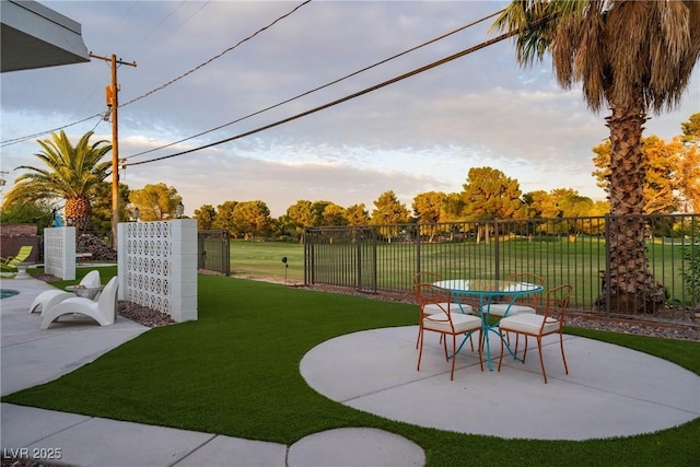 3586 Spencer St, Las Vegas, NV 89169 - yard at dusk with fence, outdoor dining area, and a patio area