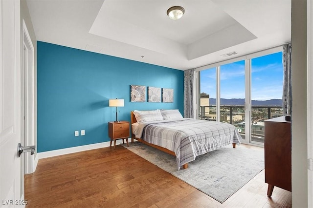 150 Las Vegas Blvd Unit 918, Las Vegas, NV 89101 - bedroom with a tray ceiling, floor to ceiling windows, a mountain view, wood finished floors, and access to exterior