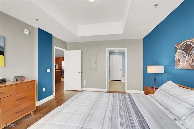 150 Las Vegas Blvd Unit 918, Las Vegas, NV 89101 - bedroom featuring electric panel, baseboards, a raised ceiling, and wood finished floors