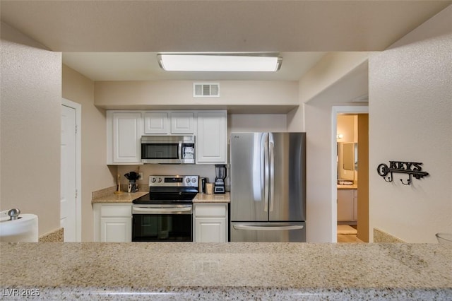 8000 Badura Ave Unit 2063, Las Vegas, NV 89113 - kitchen with appliances with stainless steel finishes, white cabinets, and light stone countertops