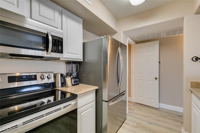 8000 Badura Ave Unit 2063, Las Vegas, NV 89113 - kitchen with appliances with stainless steel finishes, light wood-style flooring, white cabinetry, and baseboards