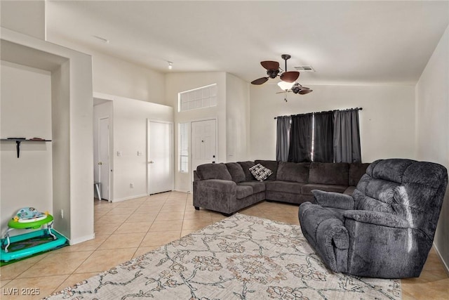living area featuring light tile patterned floors, a ceiling fan, vaulted ceiling, visible vents, and baseboards