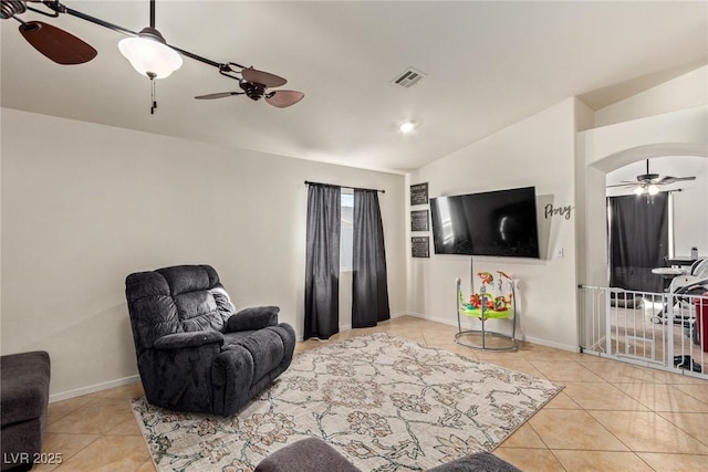 living area featuring visible vents, baseboards, ceiling fan, tile patterned flooring, and lofted ceiling