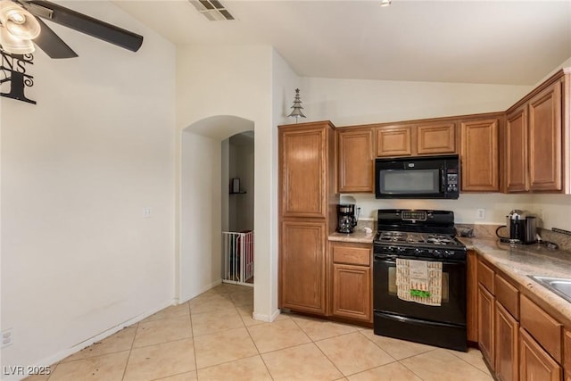 kitchen featuring arched walkways, visible vents, black appliances, lofted ceiling, and brown cabinets