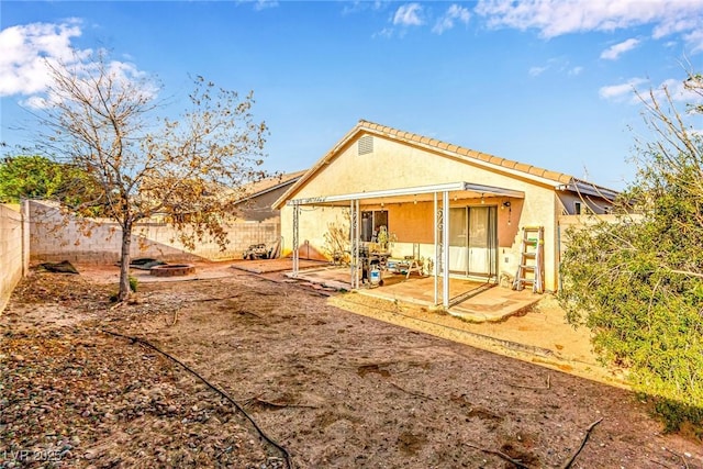 rear view of house with a patio area, a fenced backyard, and stucco siding