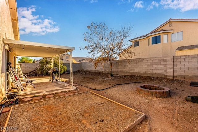 view of yard with a patio, a fenced backyard, and a fire pit