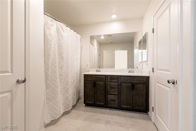 full bathroom with double vanity, a sink, tile patterned flooring, and recessed lighting