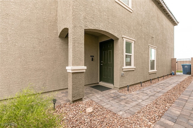 entrance to property featuring stucco siding