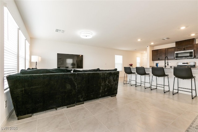 living area with recessed lighting, light tile patterned floors, and visible vents