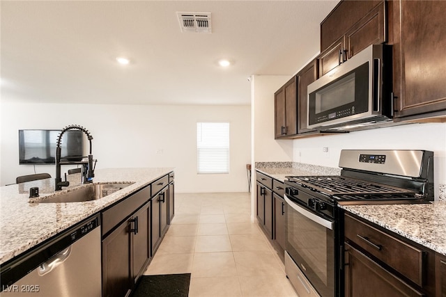 kitchen featuring stainless steel appliances, visible vents, a sink, and dark brown cabinets