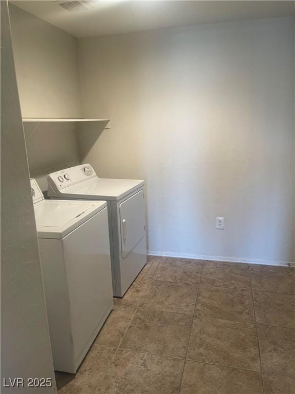 washroom with baseboards, washing machine and clothes dryer, and laundry area