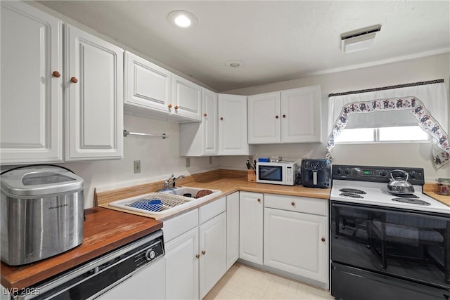 kitchen with wooden counters, white appliances, white cabinetry, and a sink