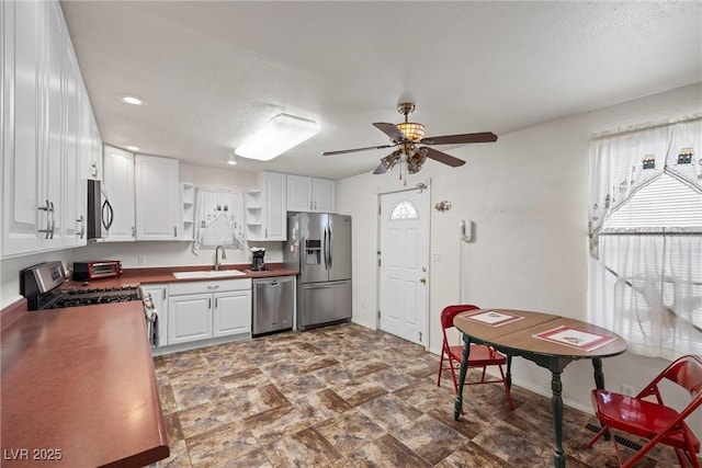 kitchen featuring open shelves, a sink, white cabinets, a ceiling fan, and appliances with stainless steel finishes