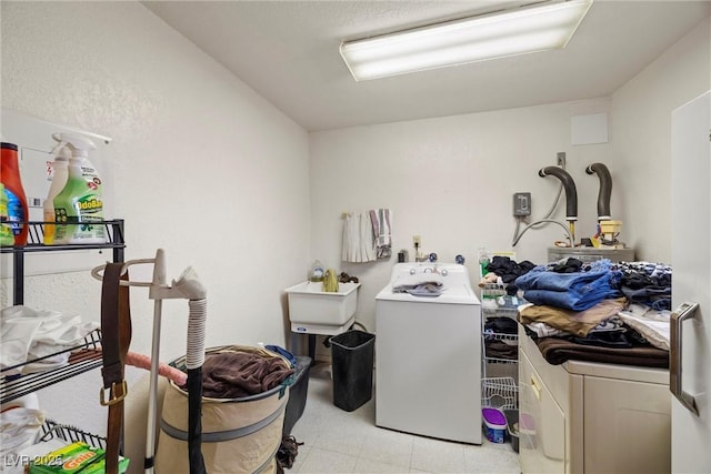 washroom featuring washing machine and dryer, a sink, and laundry area