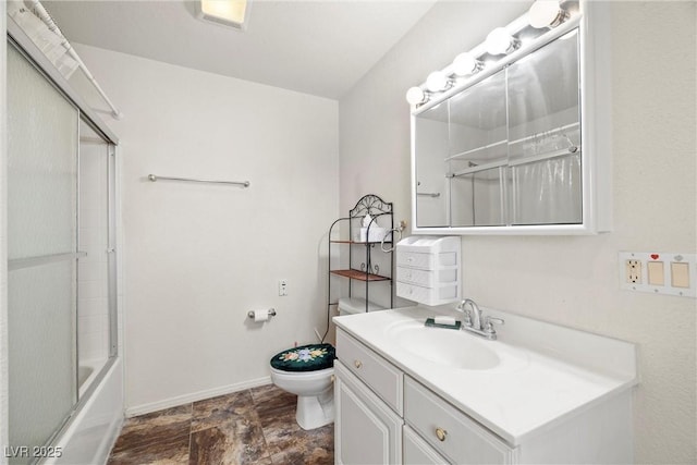 full bath with toilet, vanity, shower / bath combination with glass door, and baseboards