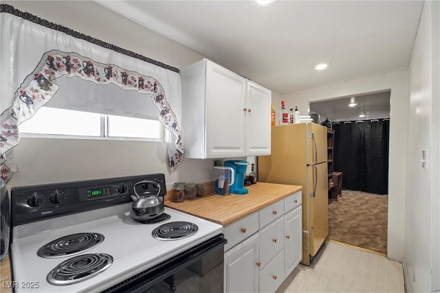 kitchen with light countertops, freestanding refrigerator, white cabinetry, range with electric stovetop, and recessed lighting