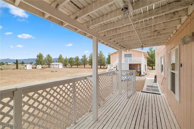 deck featuring an outbuilding, a mountain view, and a storage shed