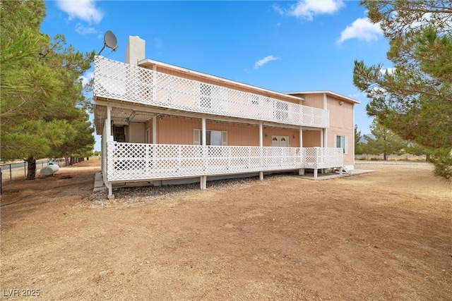 back of house featuring a chimney