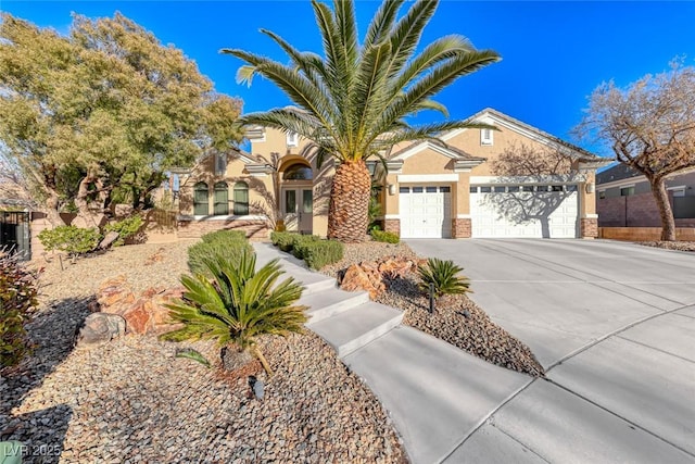 2064 Poetry Ave, Henderson, NV 89052 - view of front of home with driveway, stone siding, an attached garage, and stucco siding