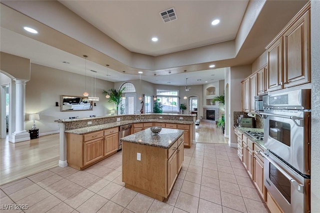 2064 Poetry Ave, Henderson, NV 89052 - kitchen with open floor plan, ornate columns, light tile patterned floors, a spacious island, and visible vents