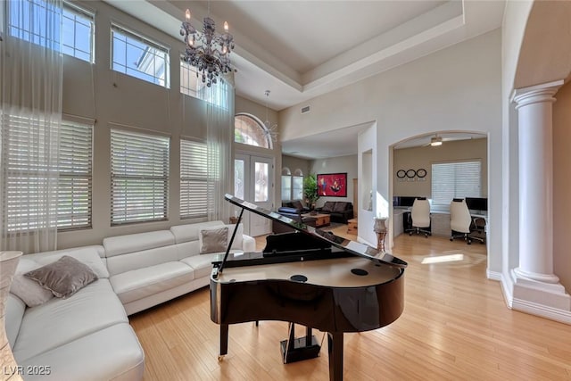 2064 Poetry Ave, Henderson, NV 89052 - living room with wood finished floors, a towering ceiling, a chandelier, and ornate columns