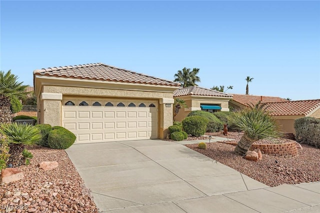 view of front of property featuring a garage, a tile roof, driveway, and stucco siding