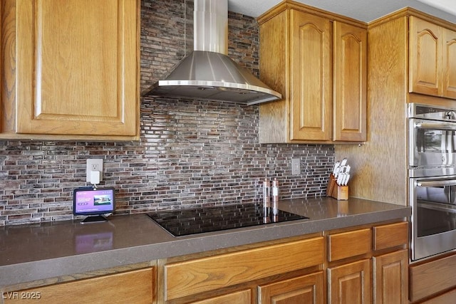 10524 Longwood Dr, Las Vegas, NV 89134 - kitchen with black electric cooktop, stainless steel double oven, backsplash, dark countertops, and wall chimney range hood