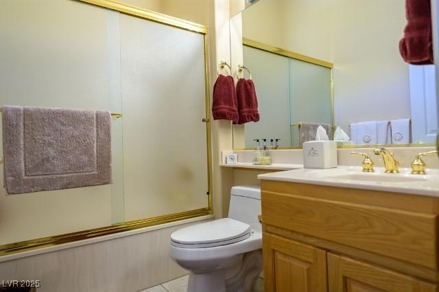 10524 Longwood Dr, Las Vegas, NV 89134 - full bathroom featuring vanity, toilet, tile patterned floors, and bath / shower combo with glass door