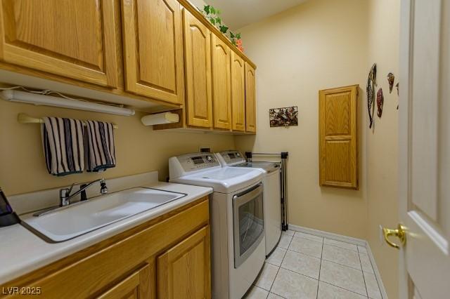 10524 Longwood Dr, Las Vegas, NV 89134 - laundry area featuring baseboards, washing machine and clothes dryer, a sink, light tile patterned flooring, and cabinet space