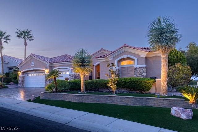 10524 Longwood Dr, Las Vegas, NV 89134 - mediterranean / spanish-style house with a tile roof, stucco siding, stone siding, driveway, and a garage