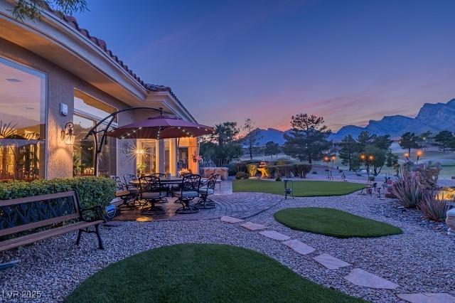 10524 Longwood Dr, Las Vegas, NV 89134 - yard at dusk with a patio and a mountain view