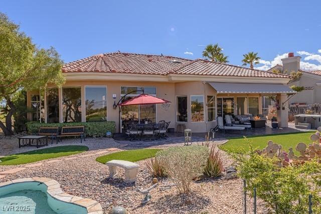 10524 Longwood Dr, Las Vegas, NV 89134 - back of house with a patio, stucco siding, a tiled roof, and outdoor lounge area