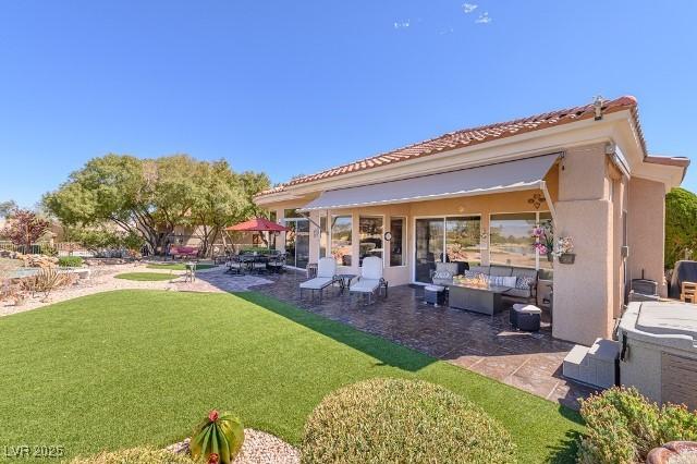 10524 Longwood Dr, Las Vegas, NV 89134 - rear view of property with a tile roof, a patio, stucco siding, and a lawn