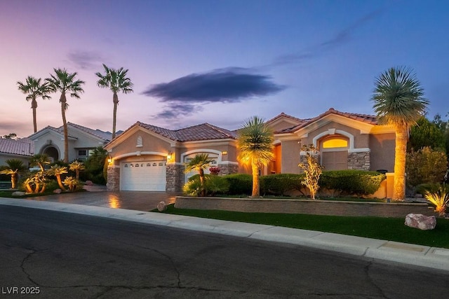 10524 Longwood Dr, Las Vegas, NV 89134 - mediterranean / spanish home featuring stone siding, aphalt driveway, a garage, a tile roof, and stucco siding
